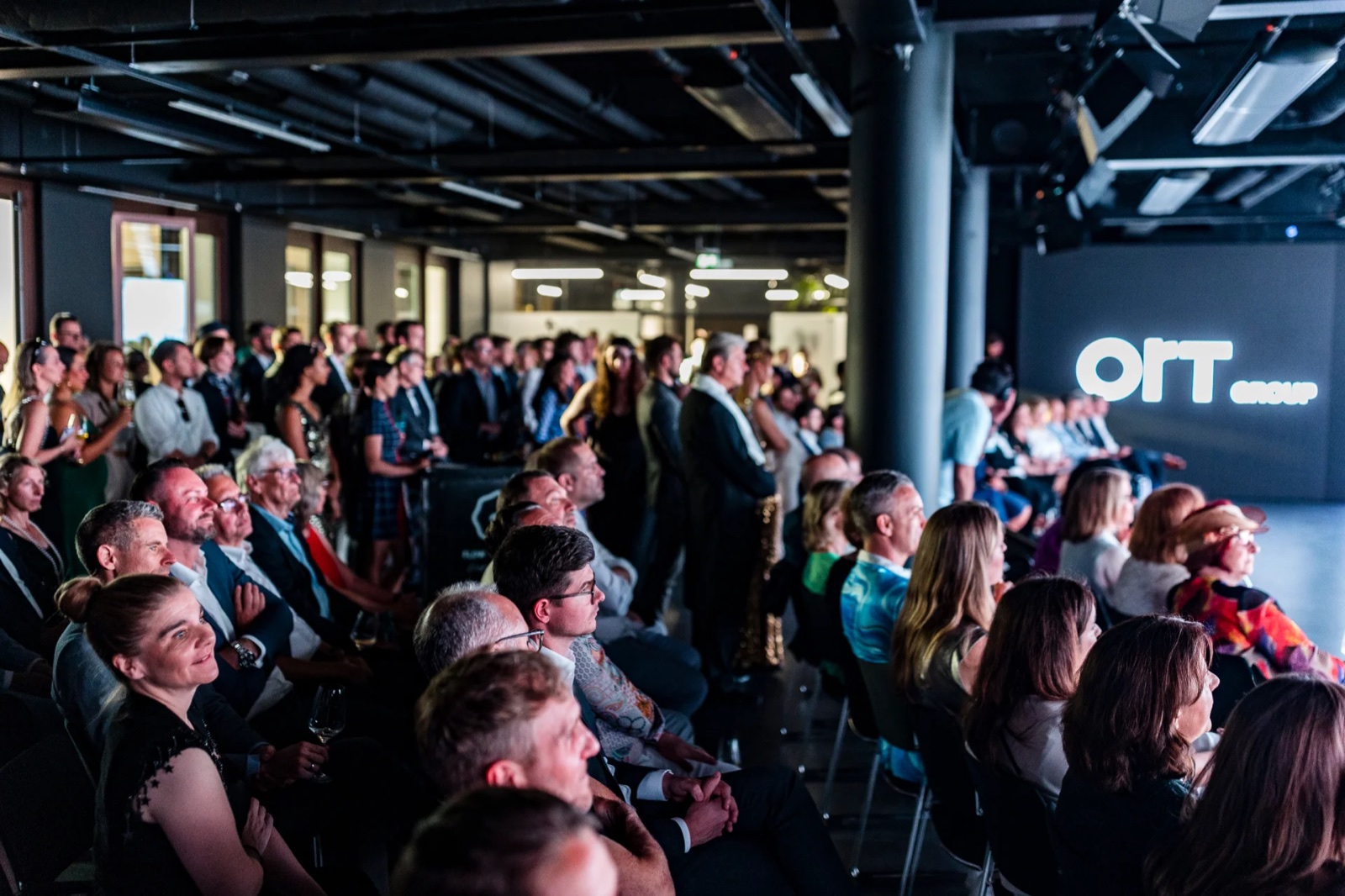 Publikum bei einem Vortrag im dunklen Event-Space von SPARK Frankfurt